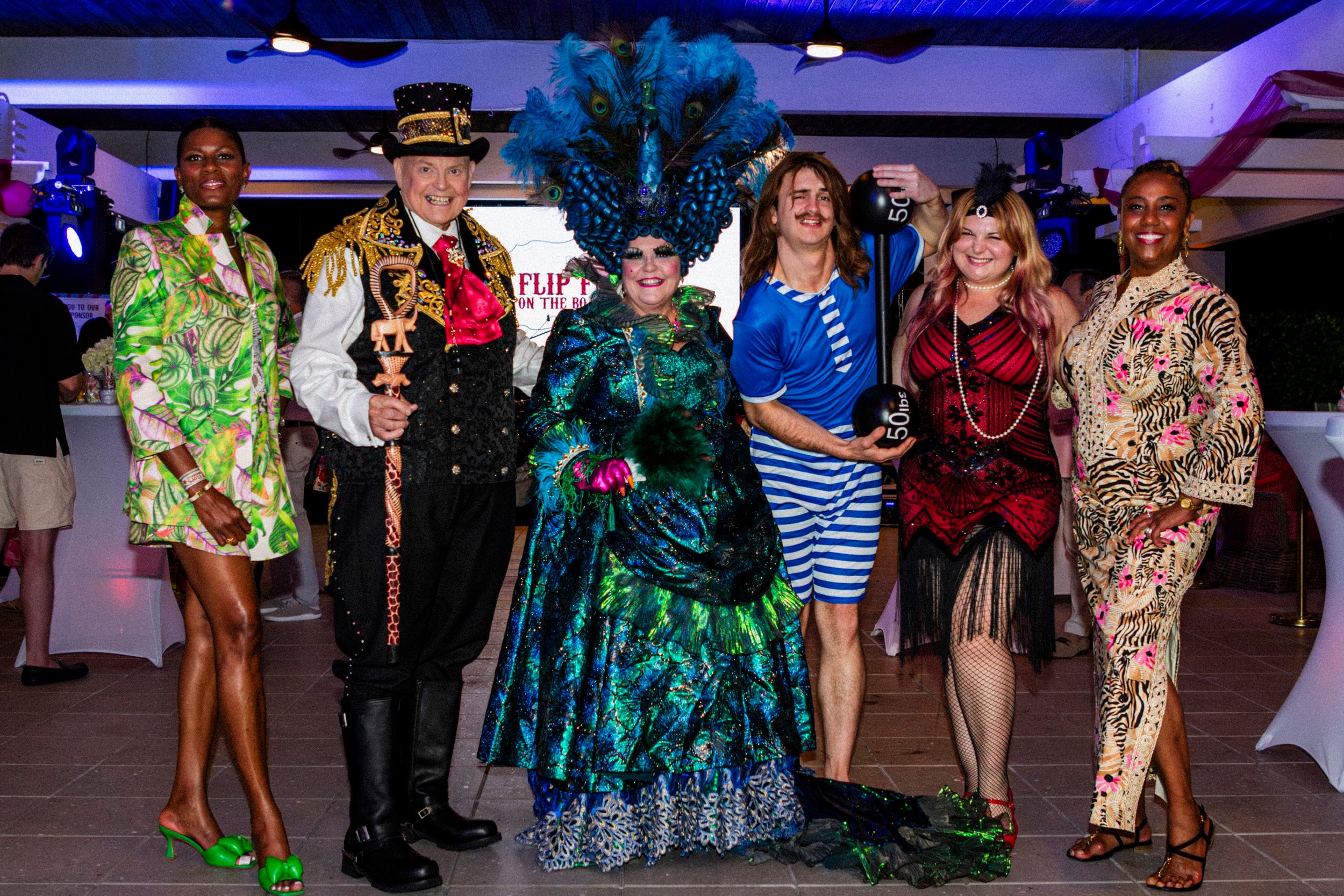 Full cast in colourful costumes at party