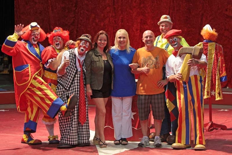 Clowns and guests posing on circus ring